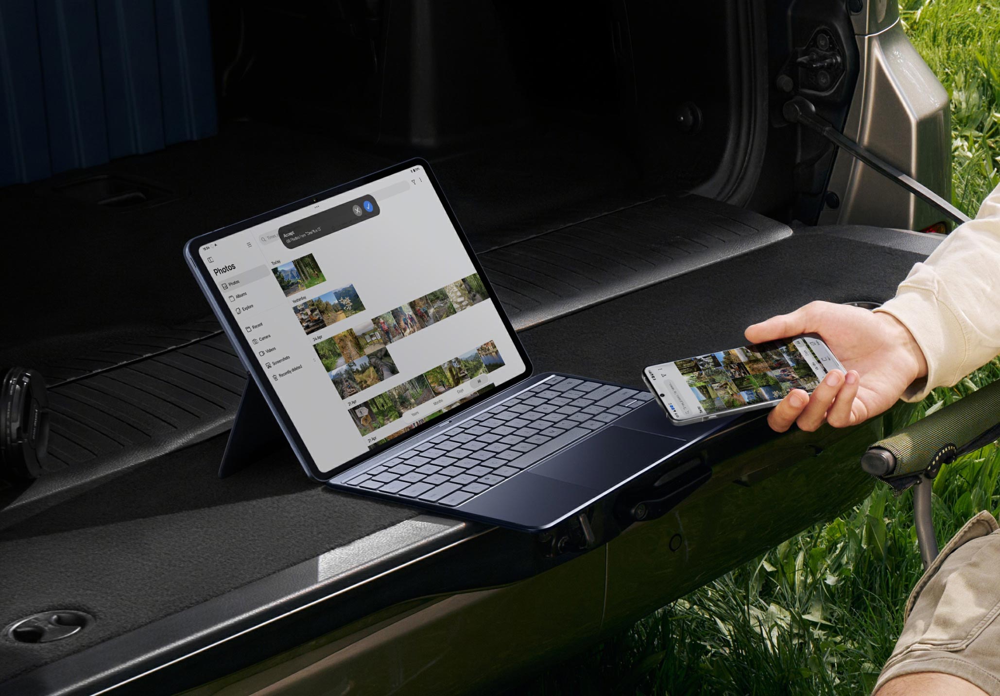 Black mobile devices displaying vibrant photo albums on a grassy background.