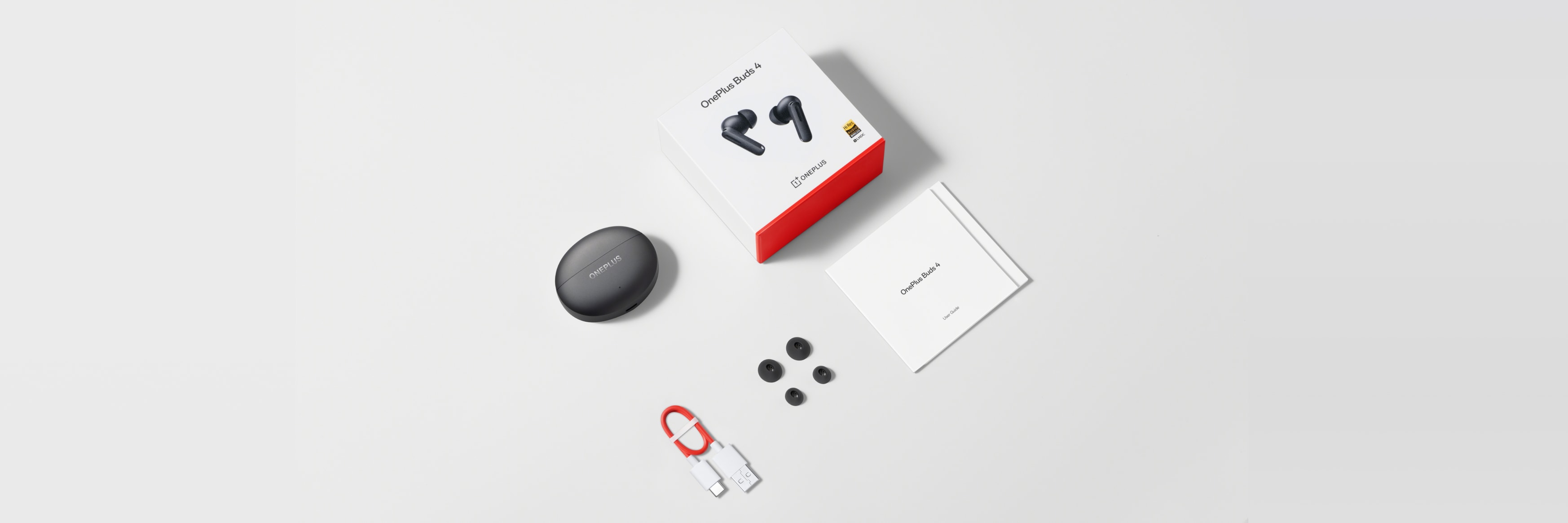Sleek black wireless earbuds with red and white packaging.